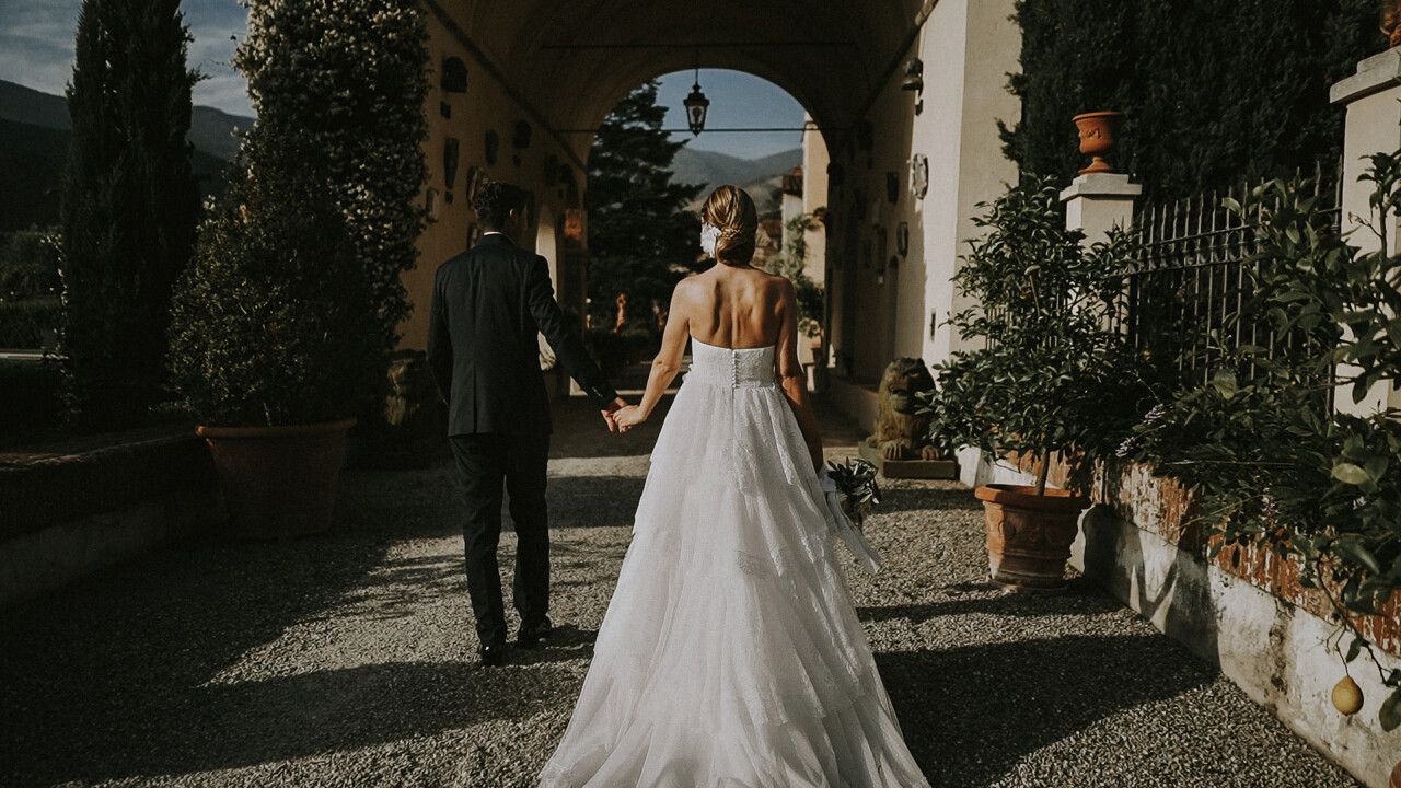 Ingresso sposi a Villa Scorzi visti di spalle, risalta l'ampia gonna bianca dell'abito di Silvia.